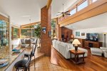 The open concept living area features vaulted ceilings and skylight windows